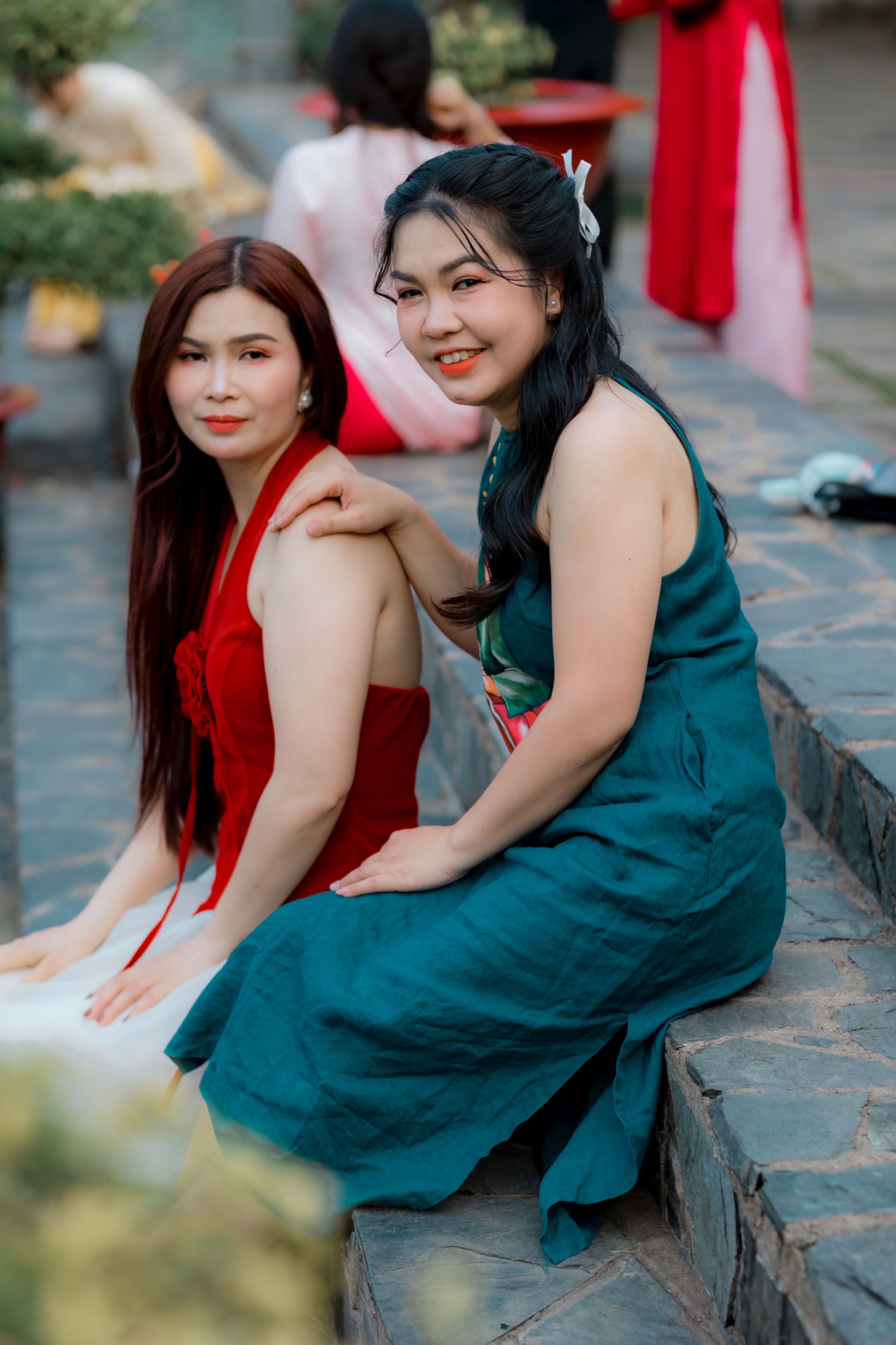 Two Women in Elegant Dresses Sitting Outdoors · Free Stock Photo