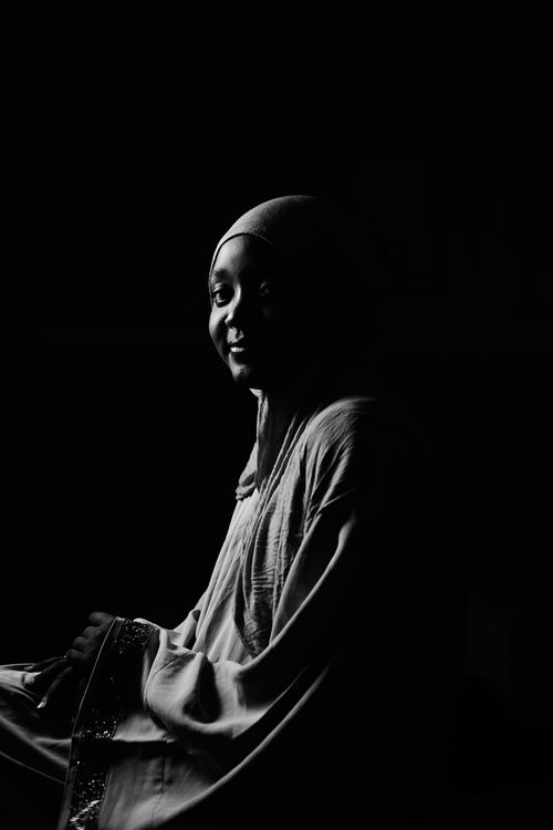 Free Elegant black and white portrait of a smiling woman with headscarf, highlighting cultural beauty. Stock Photo
