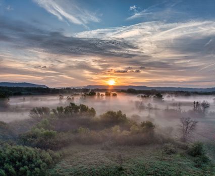 Aerial view of a stunning sunrise over a mist-covered landscape in Wabasha, Minnesota. Serene and beautiful.