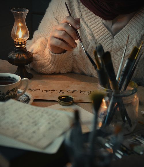 Free A serene creative setup featuring calligraphy and candlelight, exuding a warm, cozy atmosphere. Stock Photo