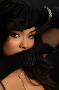 Close-up portrait of a woman in black gloves with a mysterious look.