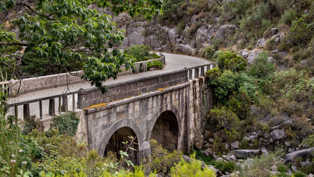 Pod vechi de piatră cu arcade, într-un peisaj verde din regiunea Gerês