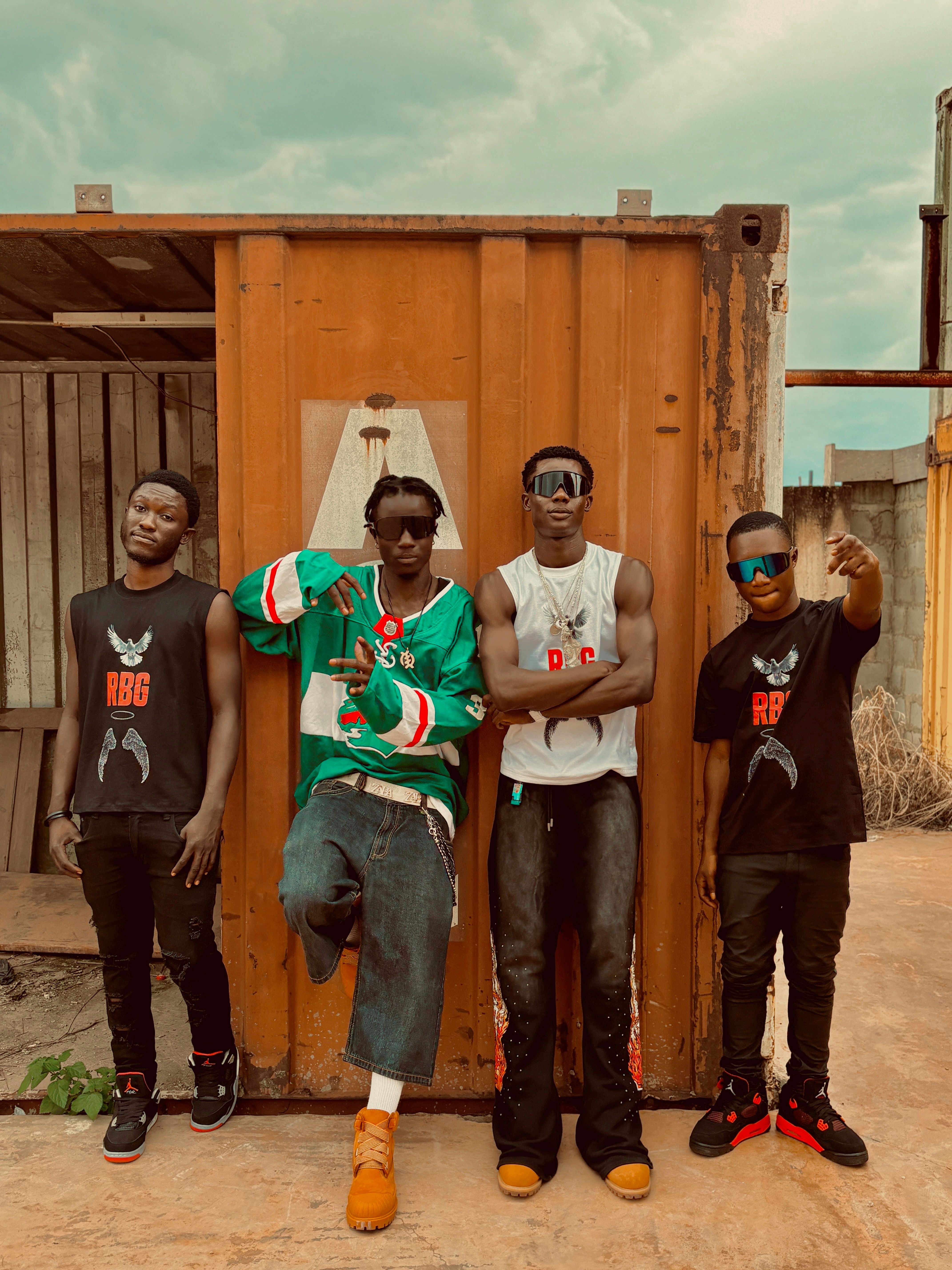 Four young men in stylish streetwear posing confidently outdoors.