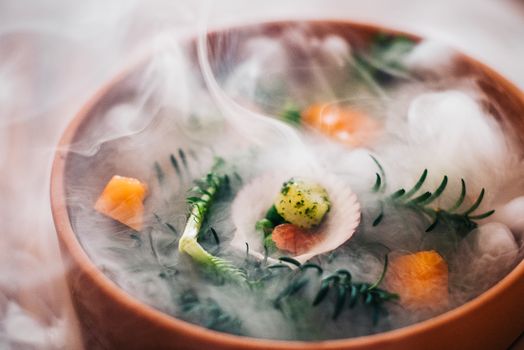 A beautifully plated gourmet seafood dish with herbs and smoke rising for an artistic effect.
