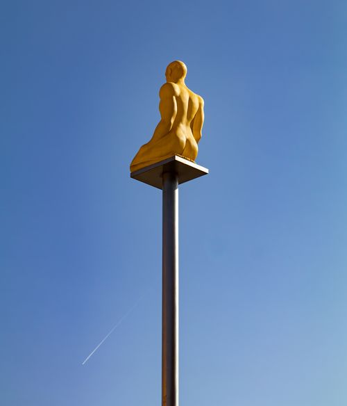 Free A striking golden sculpture on a pole set against a clear blue sky in Nice, France. Stock Photo