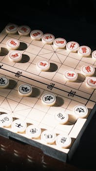An overhead view of a traditional Chinese Xiangqi board game setup with game pieces.