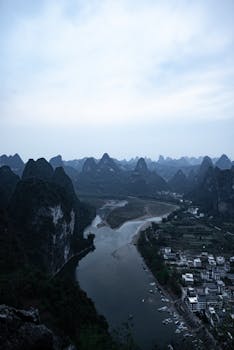 Aerial view of Li River winding through karst peaks at twilight near Yangshuo, China.