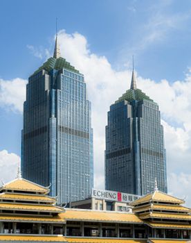 Two modern skyscrapers with spires set against a clear blue sky, showcasing contemporary architecture.
