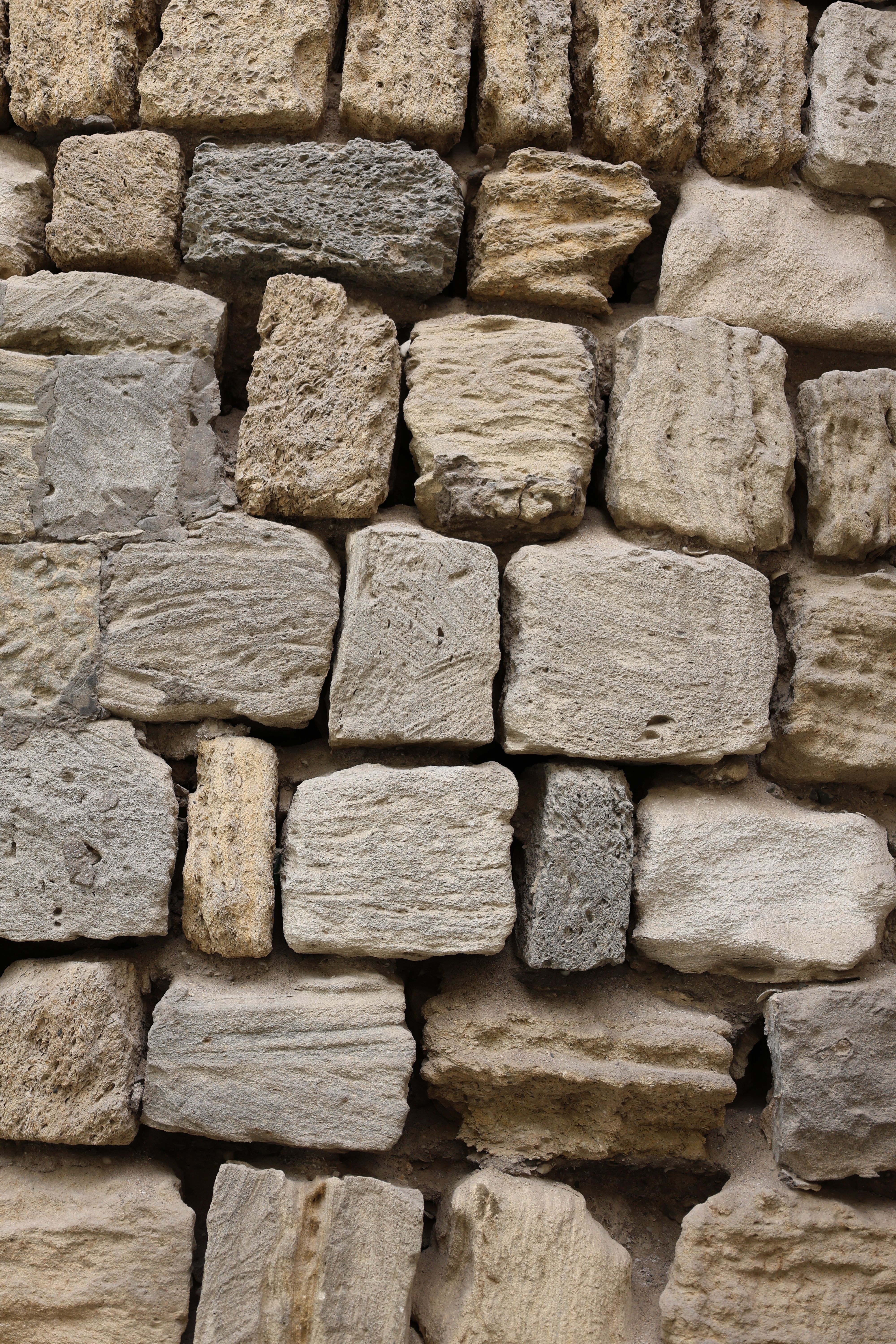 Detailed view of a rustic stone wall with varied textures and colors.