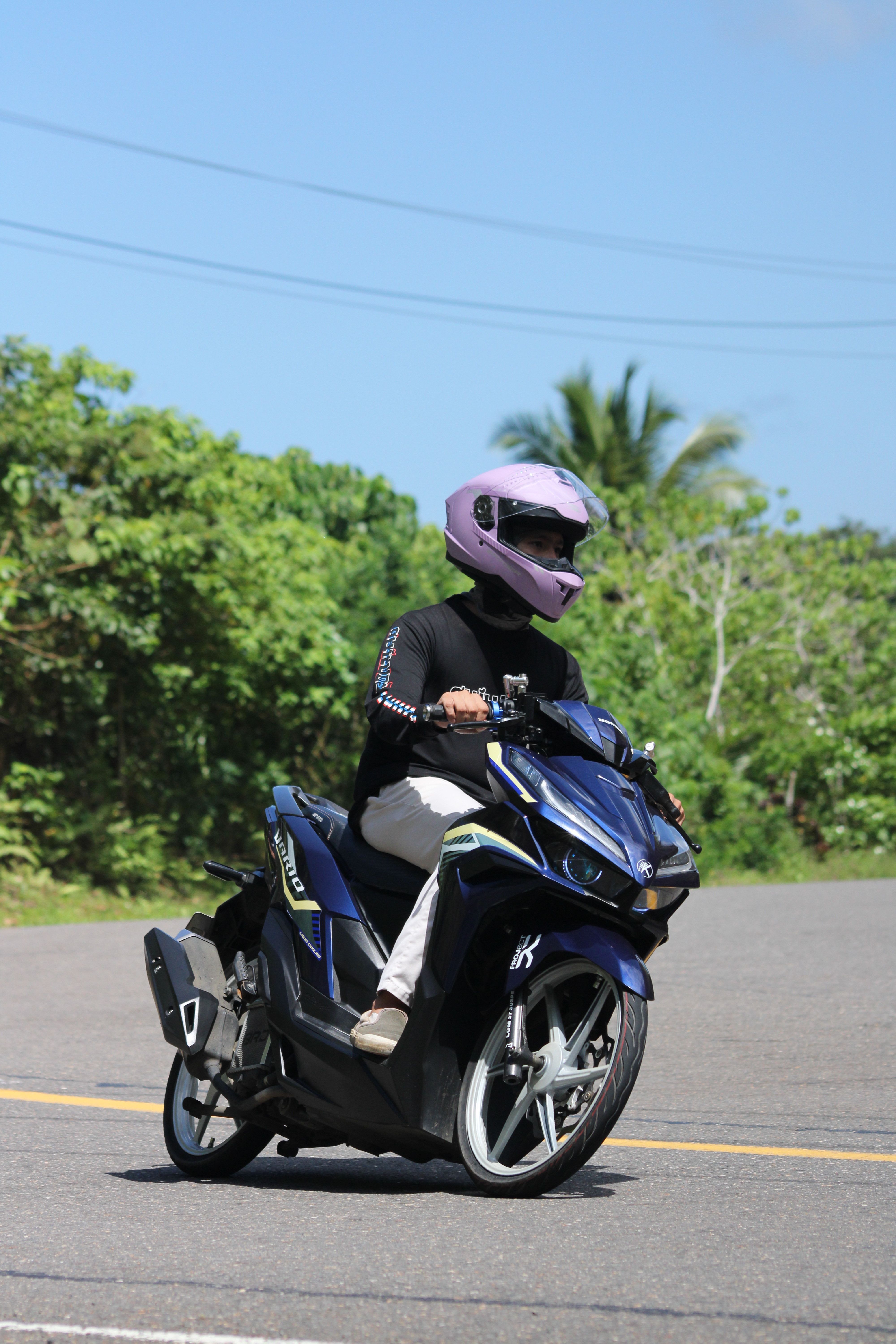 Person Riding Scooter on Sunny Road · Free Stock Photo