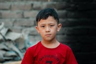 Young boy in red shirt in urban setting