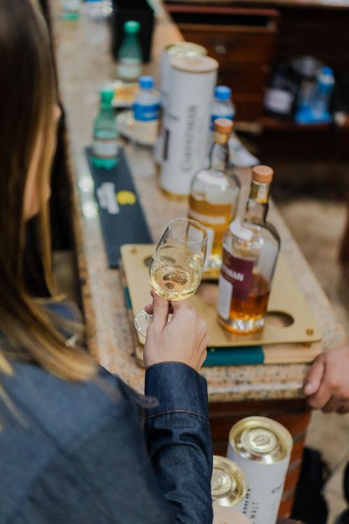 Taster smelling a whiskey glass at a bar counter