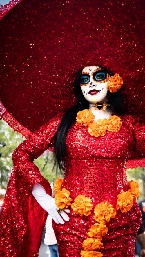 Free Woman in a colorful Day of the Dead costume with red sequins and orange flowers. Stock Photo