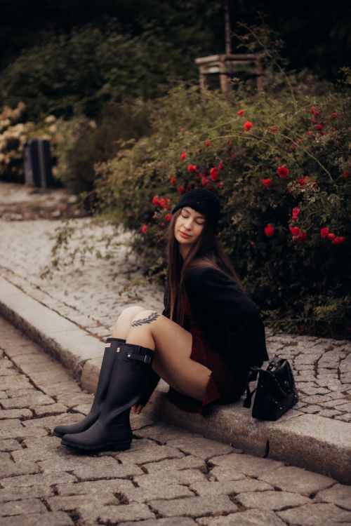 Young Woman Relaxing on Cobblestone Street · Free Stock Photo