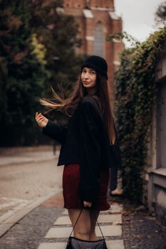 Stylish woman posing outdoors in autumn attire. Perfect for urban fashion and seasonal photography.