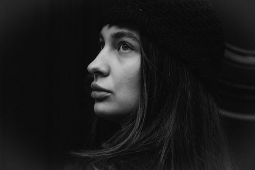Free Artistic black and white portrait capturing a thoughtful woman in side profile wearing a hat. Stock Photo