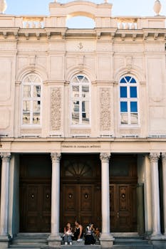 Historic building facade in Istanbul with people relaxing on the steps.