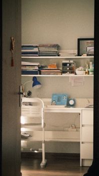 A warm, inviting home office space with lamp and organized shelves.