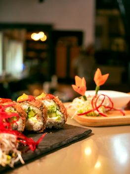 Close-up of gourmet sushi rolls with elaborate garnish, perfect for culinary themes.