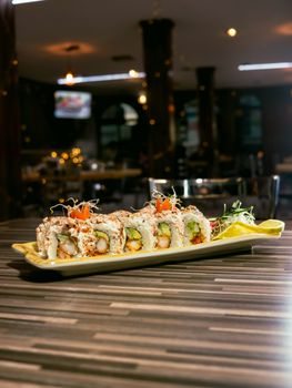 Savor delicious sushi rolls elegantly plated in a dimly lit upscale restaurant, highlighting fresh ingredients and culinary artistry.