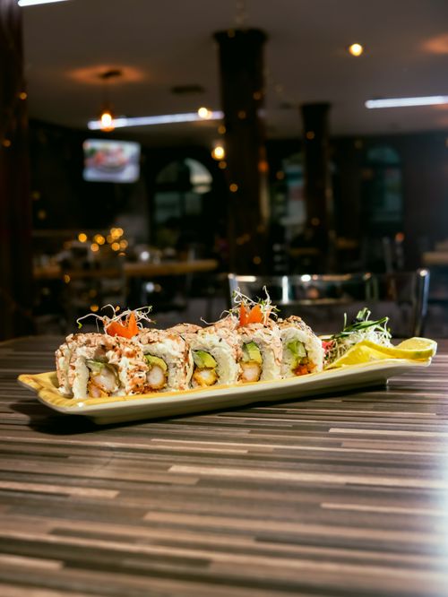 Free Savor delicious sushi rolls elegantly plated in a dimly lit upscale restaurant, highlighting fresh ingredients and culinary artistry. Stock Photo