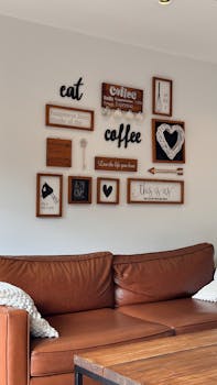 A cozy living room featuring a wall with inspirational coffee-themed decor and a leather sofa.
