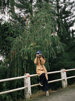 Individual capturing a moment in a tranquil outdoor park surrounded by lush greenery.