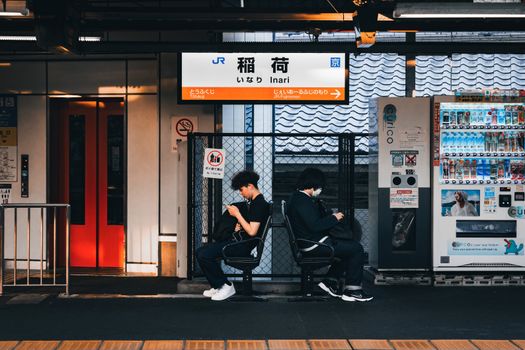 Travelers at Inari Station in Kyoto, Japan, capturing everyday commuting life.