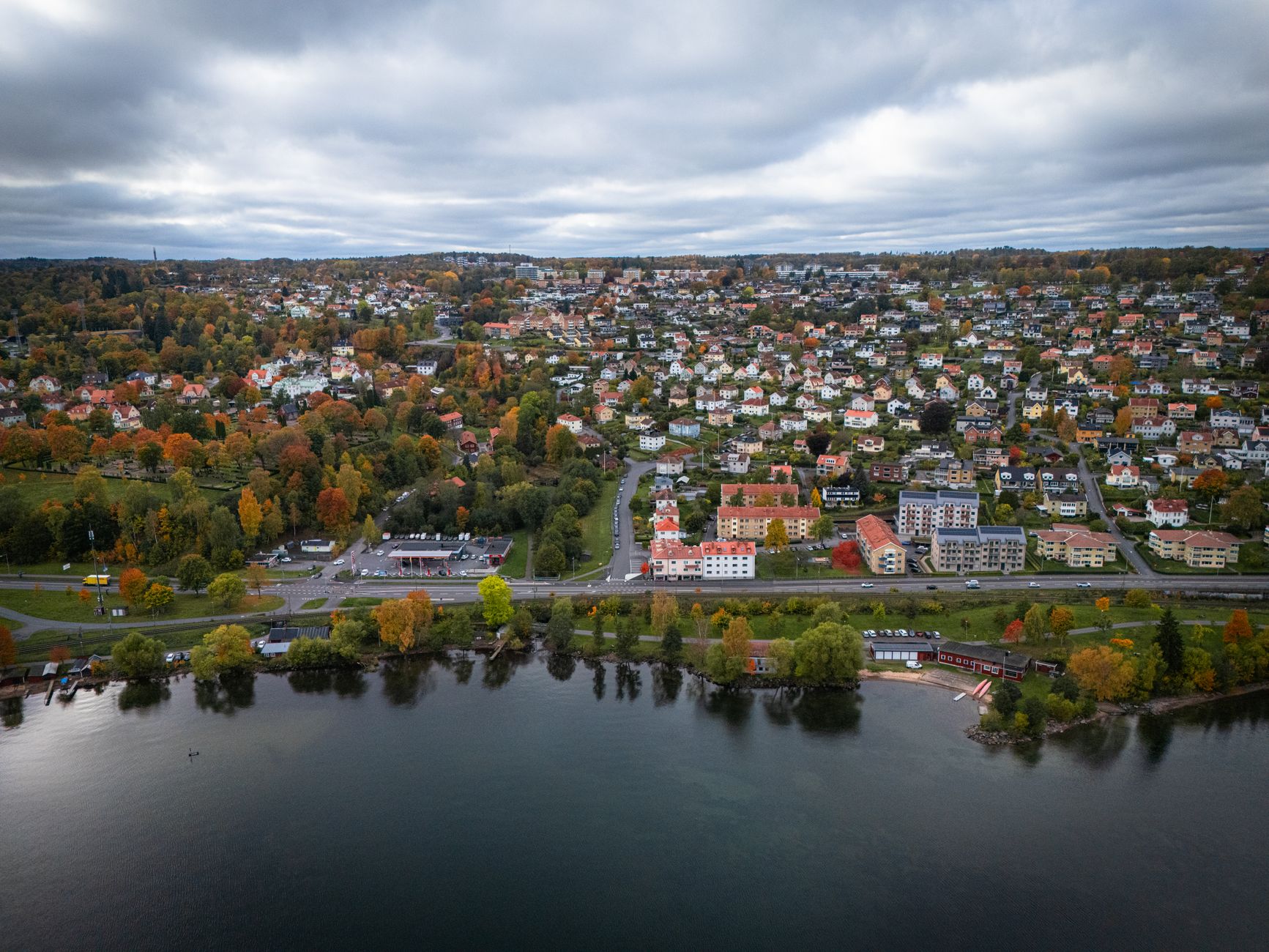 Breathtaking aerial view of Jönköping, Sweden, showcasing colorful autumn foliage and serene water.