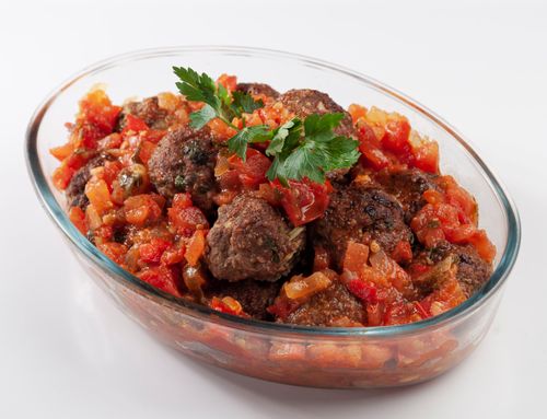 Free Tasty meatballs garnished with parsley in a vibrant tomato sauce, perfect for any meal. Stock Photo