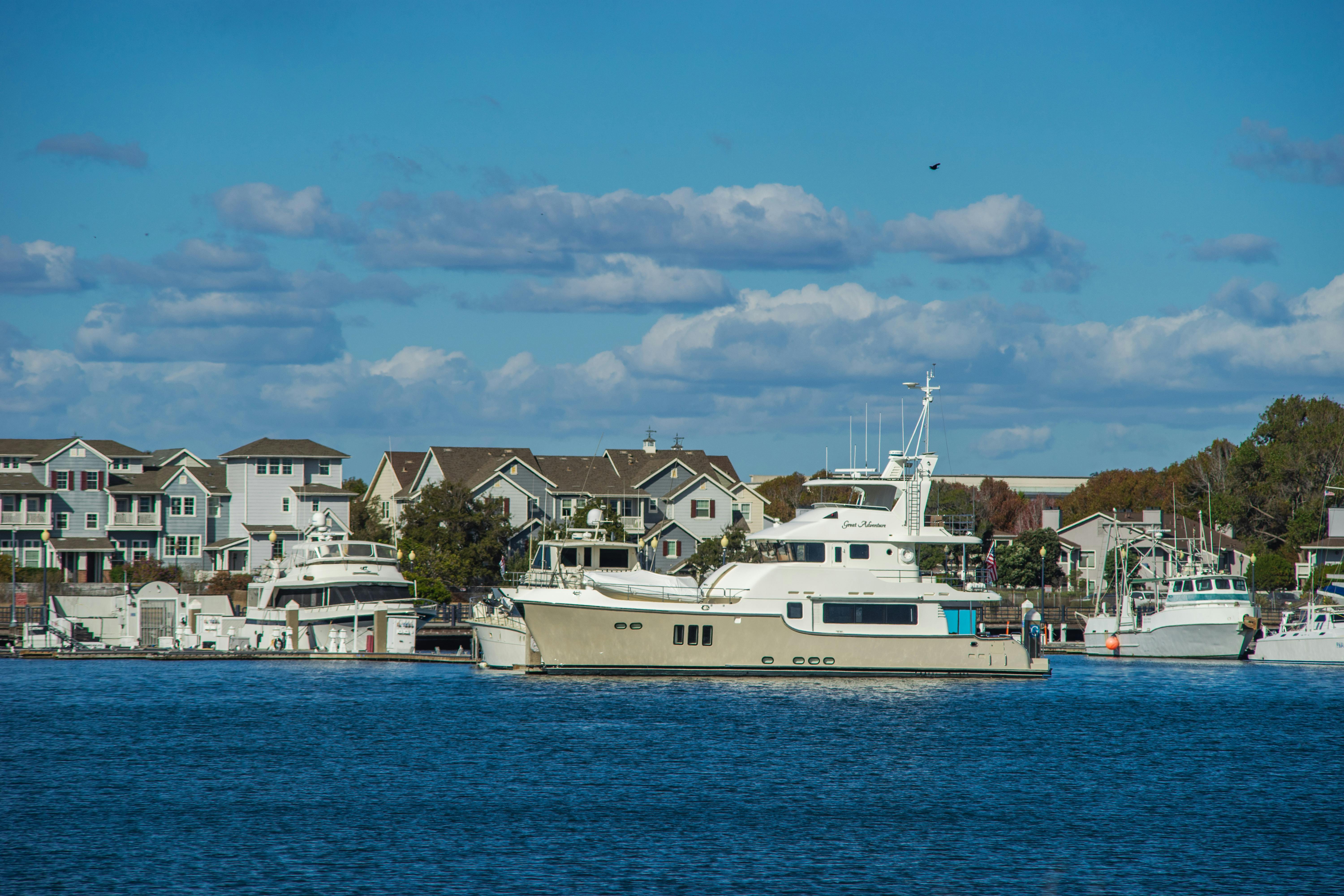 Picturesque view of yachts anchored by waterfront houses under a clear blue sky.