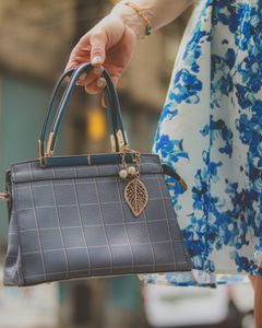 Elegant blue handbag and floral dress detail, perfect for fashion-forward styling on the go.