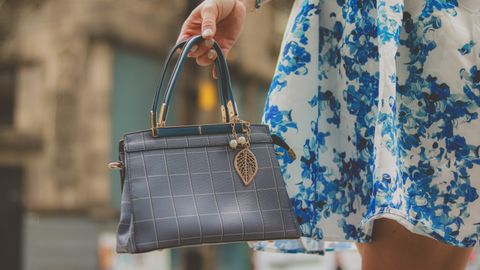 Elegant blue handbag and floral dress detail, perfect for fashion-forward styling on the go.
