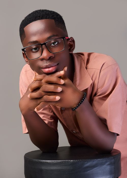 Free Young man with glasses and folded hands posing confidently indoors. Stock Photo
