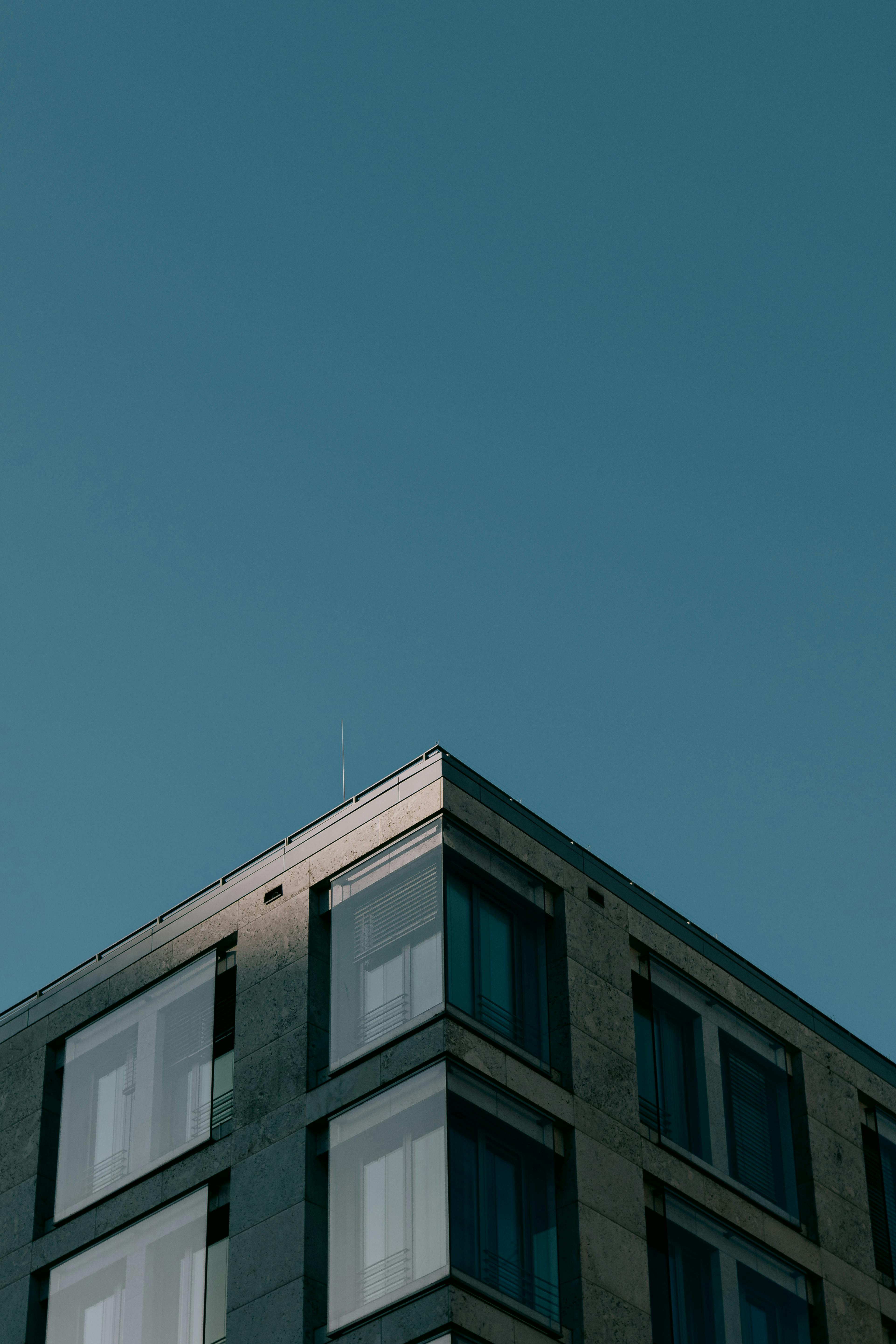 Kostenlos Minimalistische Architekturaufnahme einer modernen Gebäudeecke unter einem klaren blauen Himmel. Stock-Foto
