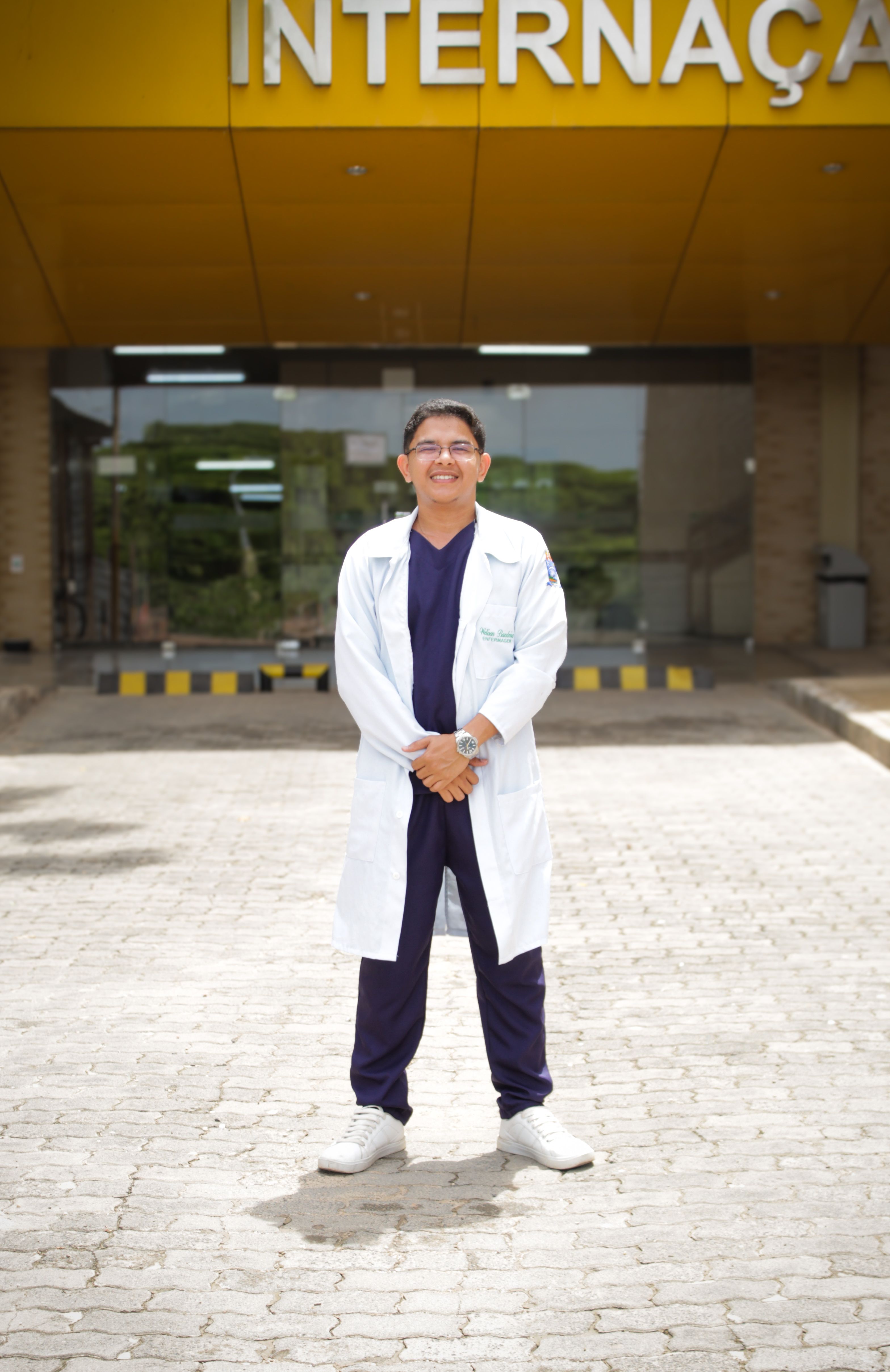 Smiling Doctor Standing Outside Hospital Entrance · Free Stock Photo