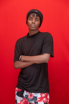 Young man posing with a confident look on a vibrant red background.