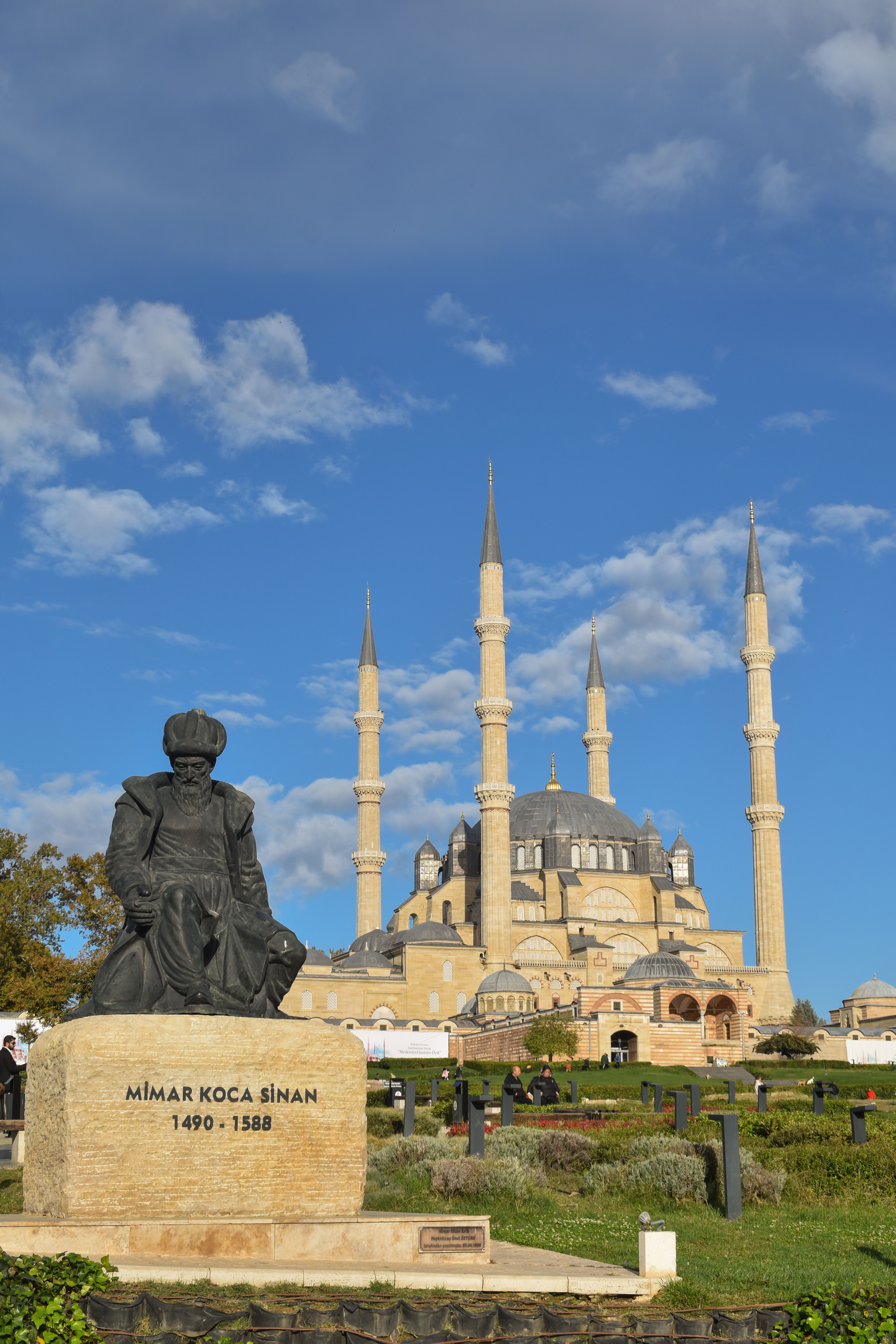 Stunning view of Selimiye Mosque and Mimar Sinan statue in Edirne with vibrant sky.