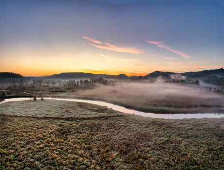 Captivating sunrise over a misty, meandering river in Tell, Wisconsin. Peaceful morning scene.