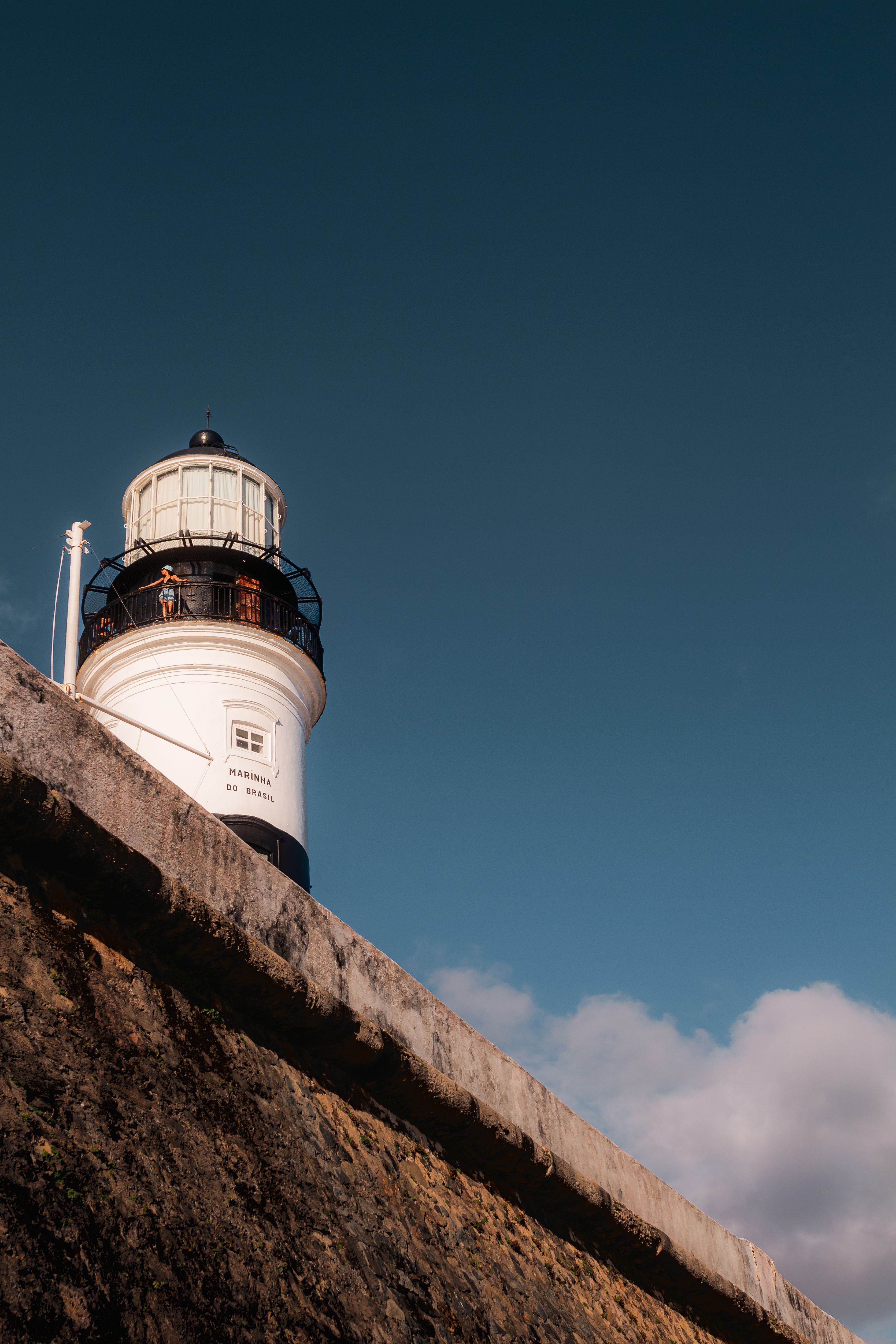 Scenic view of a lighthouse in Salvador, Brazil, under a bright blue sky.