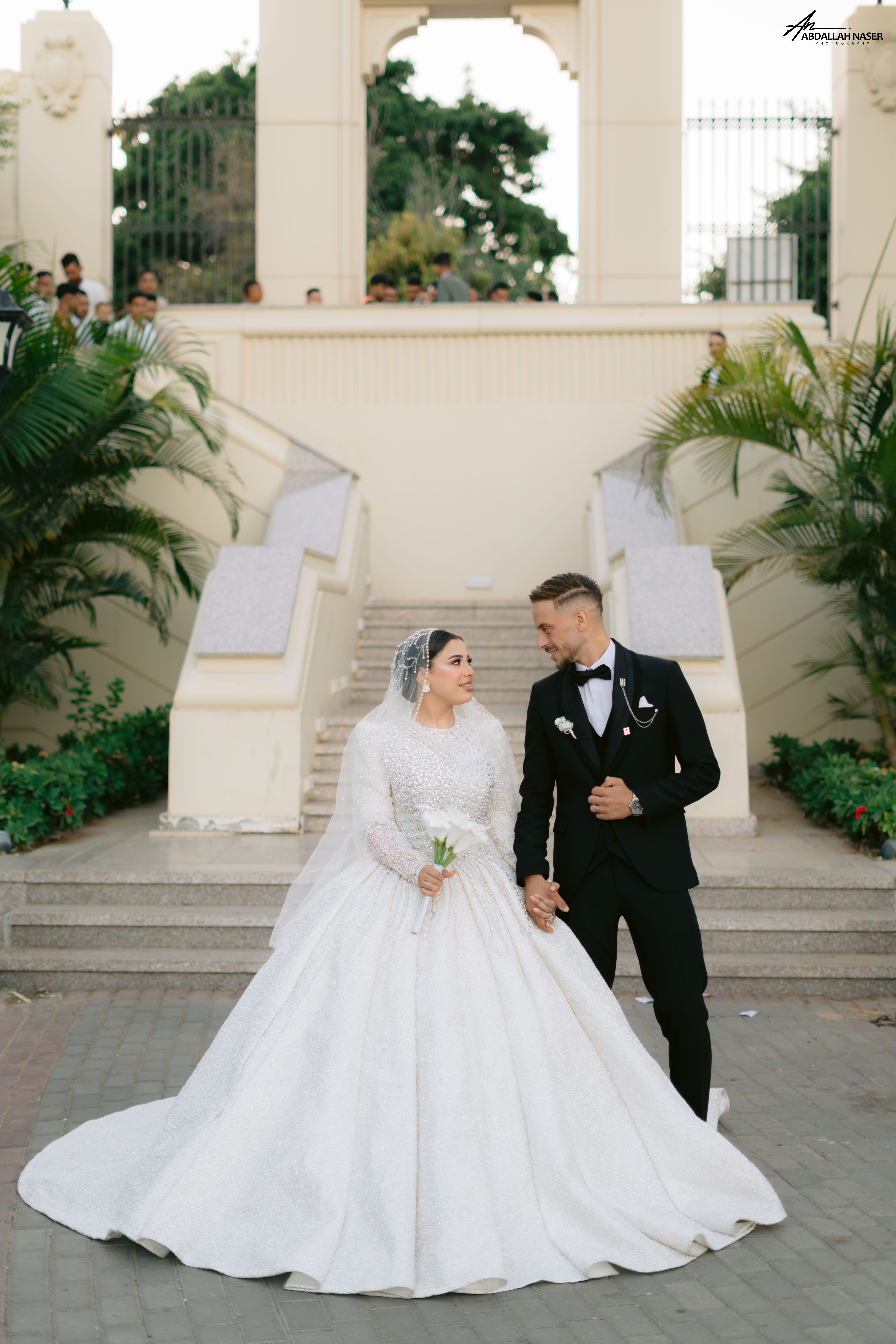 Charming photo of a couple in wedding attire standing outdoors. Ideal for wedding-themed projects.