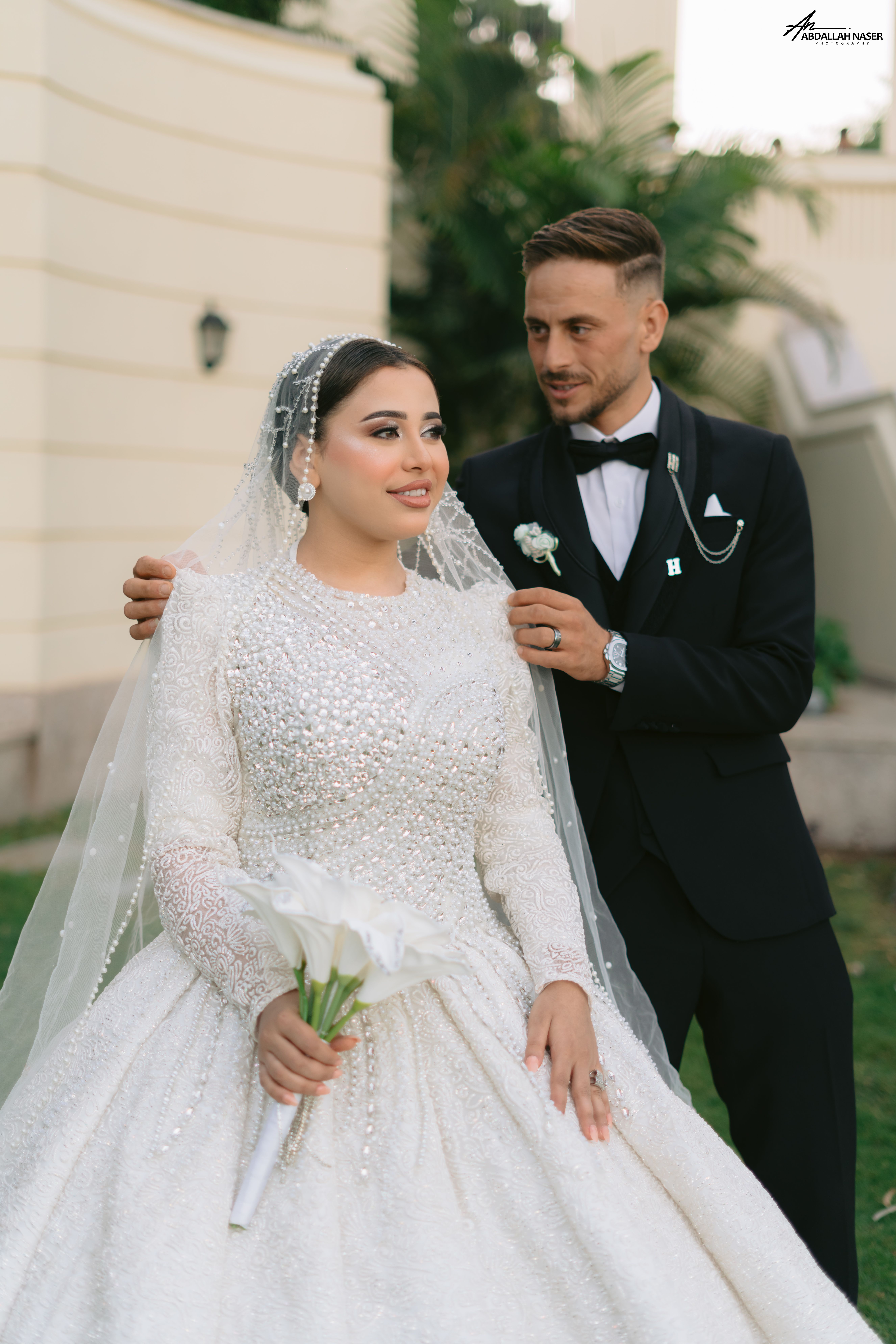 Romantic wedding portrait of a couple in a garden, showcasing elegance and style.