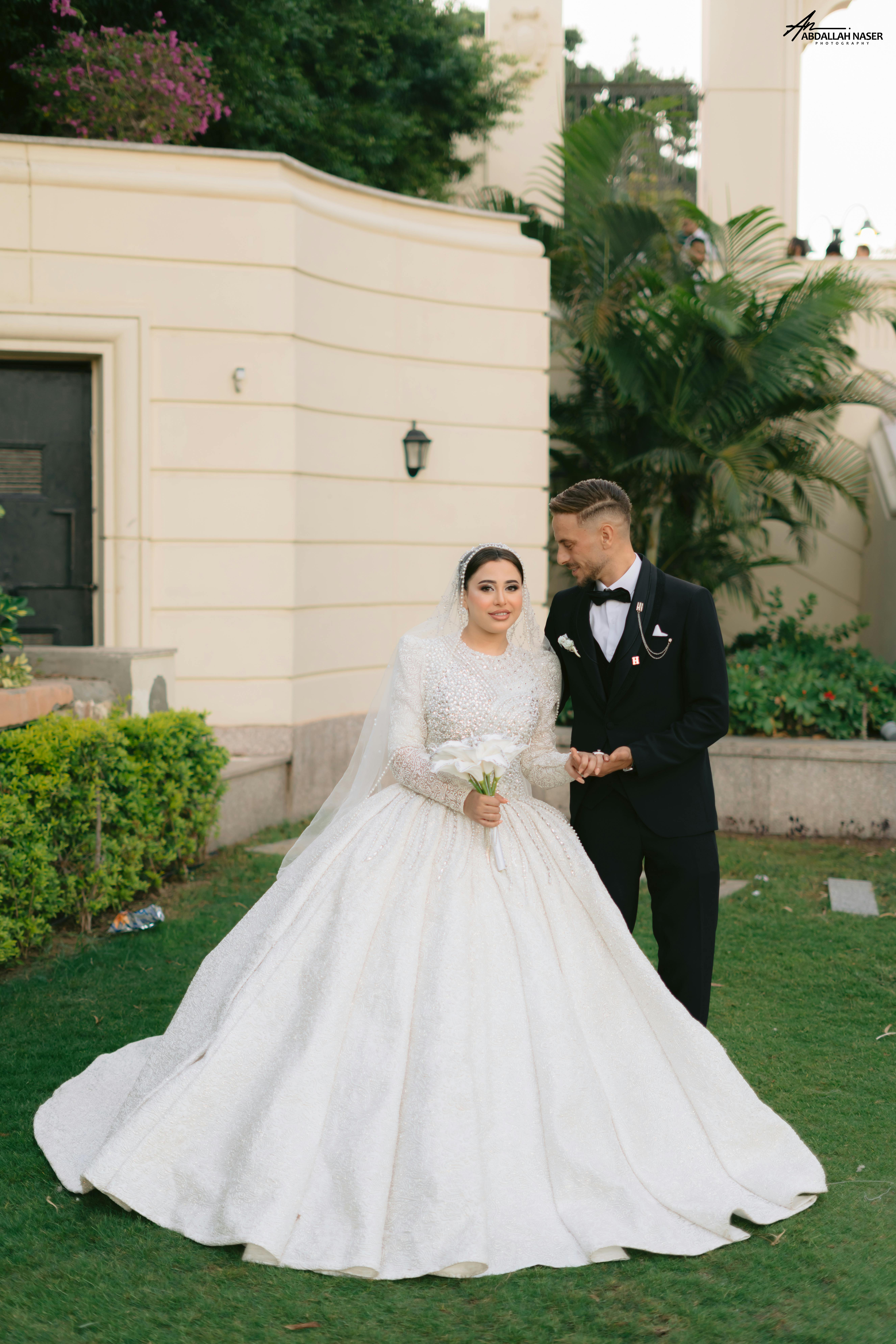 Romantic wedding portrait of a bride and groom in a lush outdoor setting.
