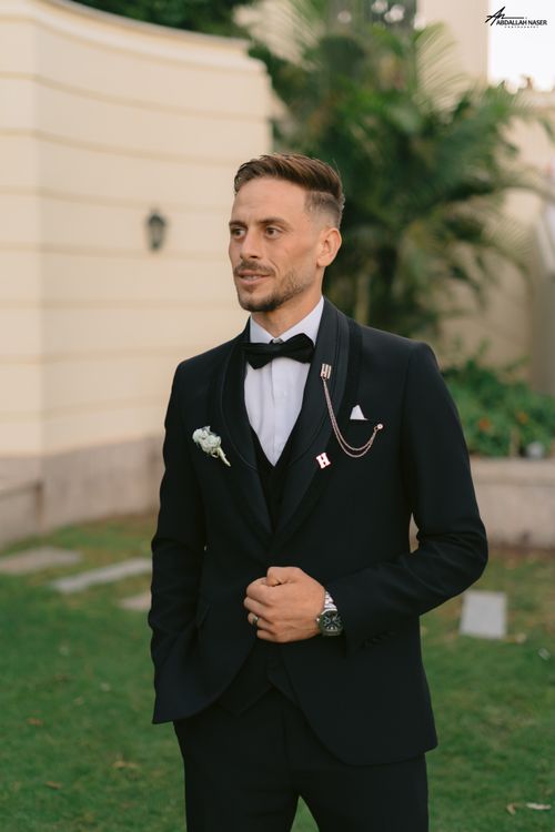 Free A groom in a stylish black tuxedo poses outdoors, exuding elegance and style. Stock Photo