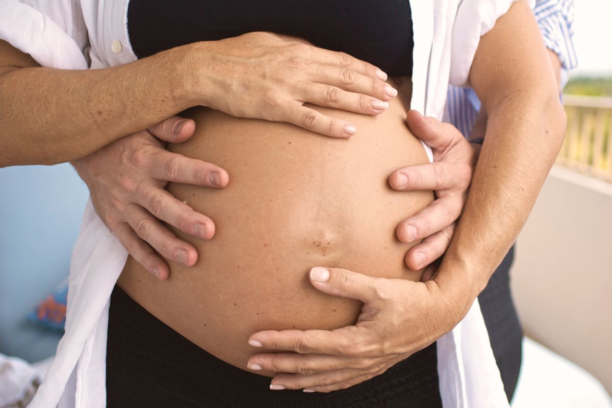 Hands around a pregnant belly
