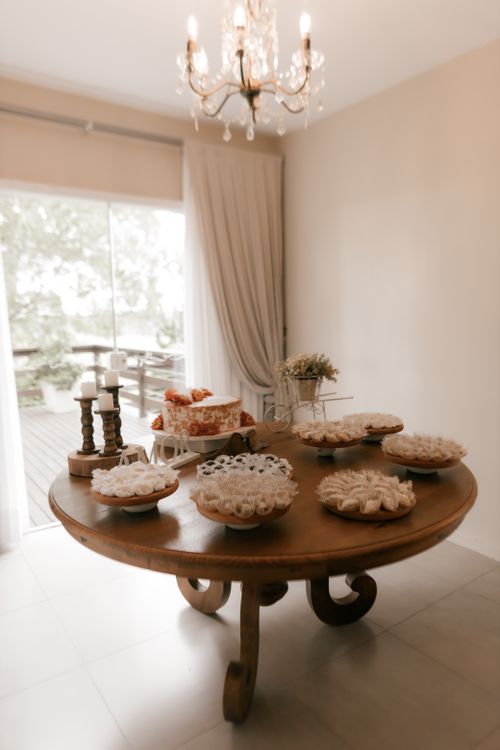 Free A warmly lit indoor dessert table adorned with various sweets and candles. Stock Photo