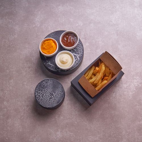 Free Elegant serving of French fries with gourmet sauces on a stylish platter. Stock Photo