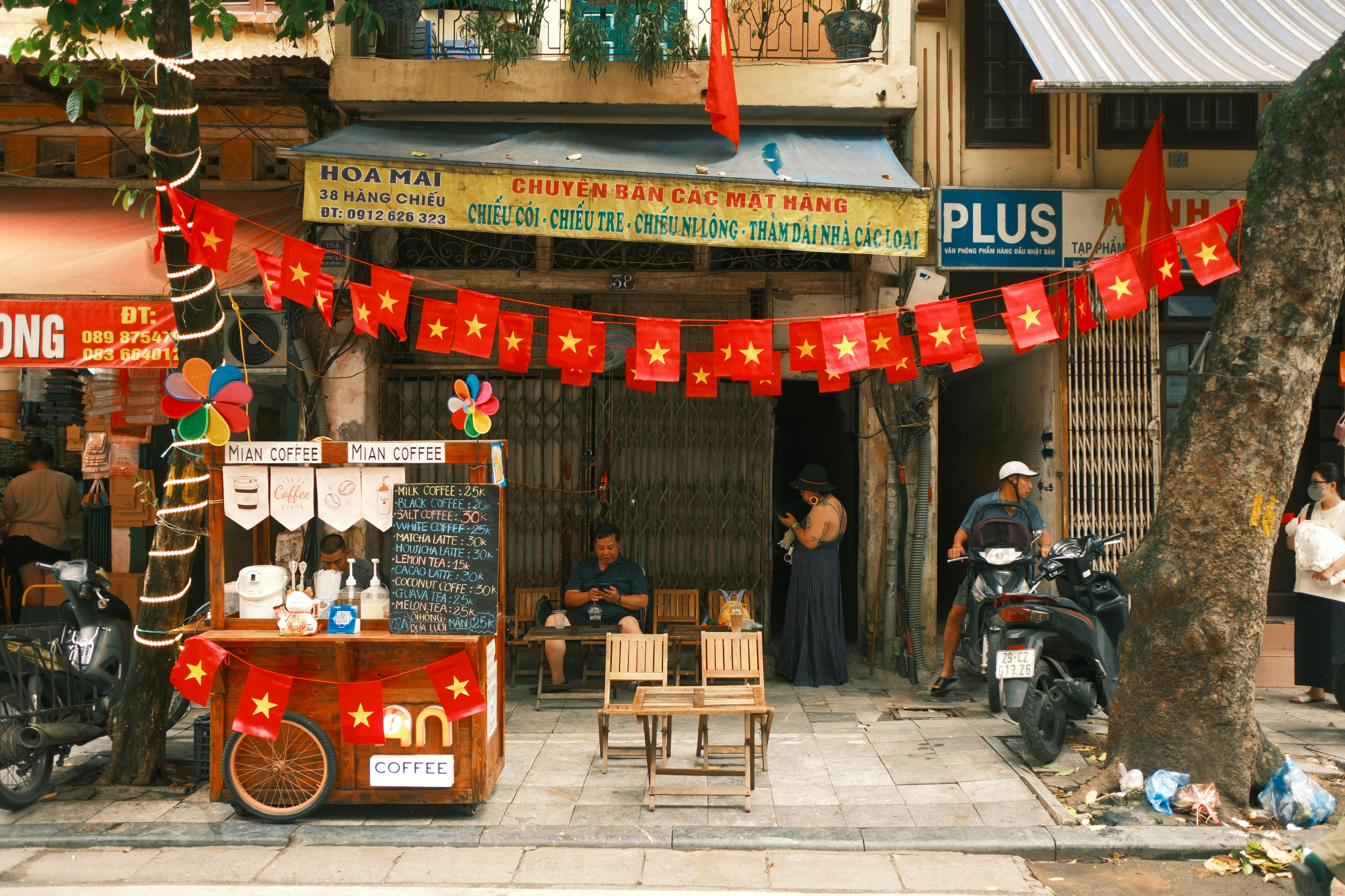 Charming Vietnamese street coffee shop with vibrant red flags creating a warm, inviting atmosphere.