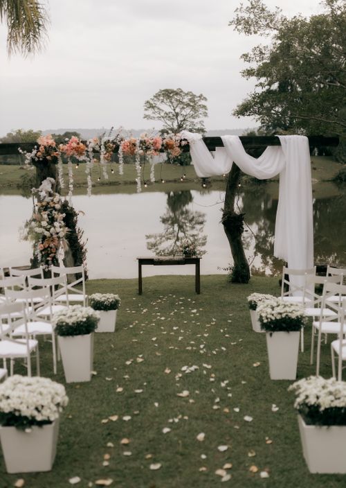 Free Beautiful floral wedding arch setup by a serene lakeside, ideal for outdoor ceremonies. Stock Photo