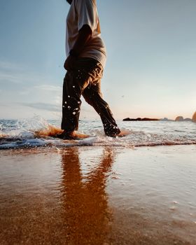 A person walking along the beach of Tioman Island during sunset, reflecting serenity and freedom.